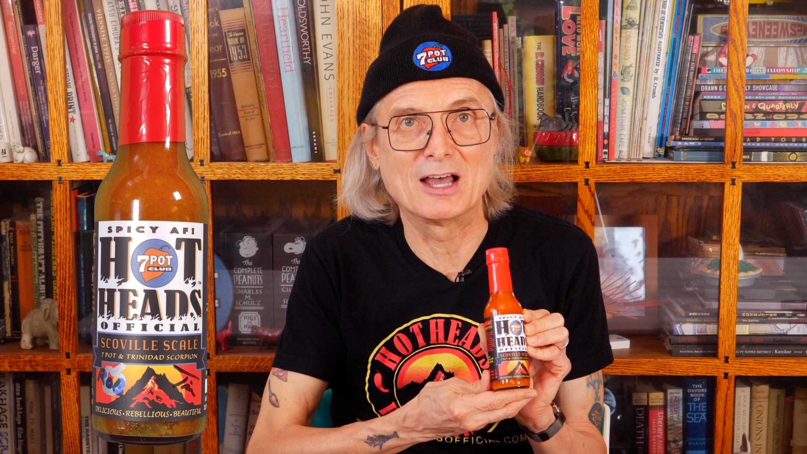 Rob is holding a hot sauce bottle. (still from YouTube video)